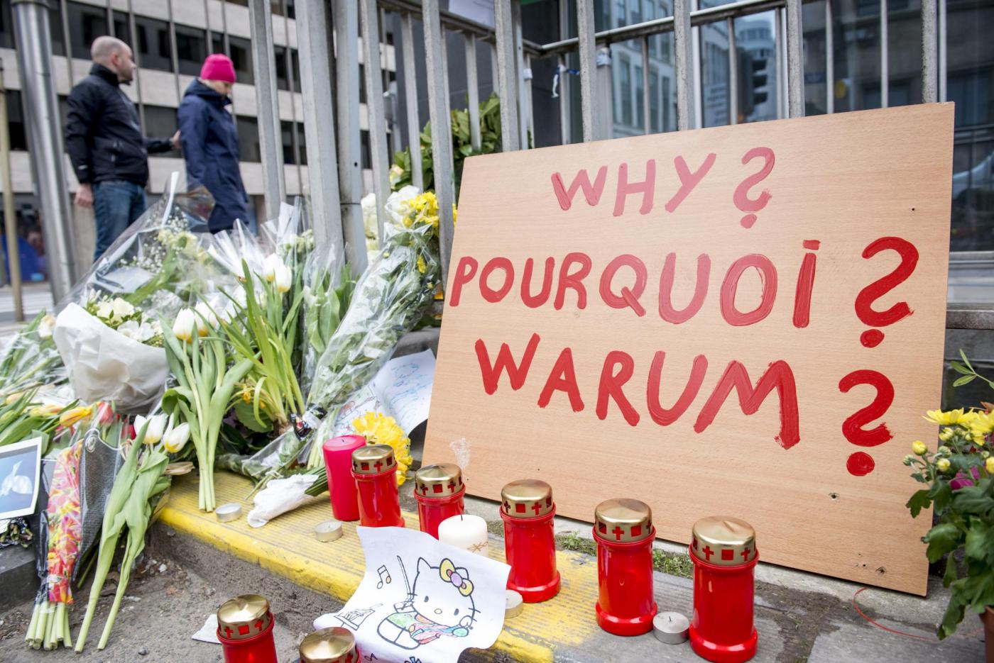 Persone portano fiori e candele nella zona dell'esplosione al Maelbeek