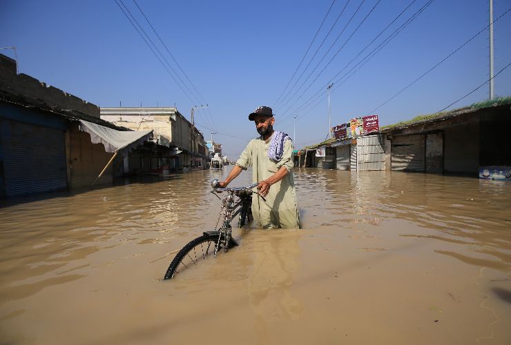 Pakistan: un uomo trascina la sua biciletta tra l'acqua dopo le inondazioni
