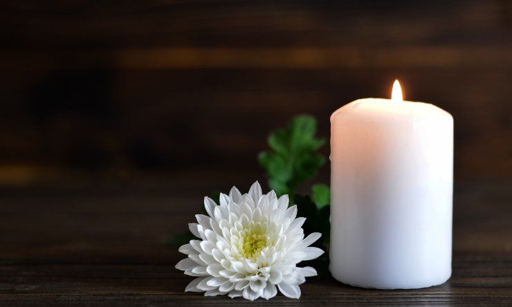 Una candela e un crisantemo bianco