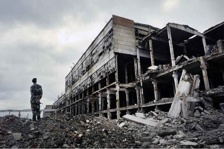 Soldato su rovine edificio bombardato